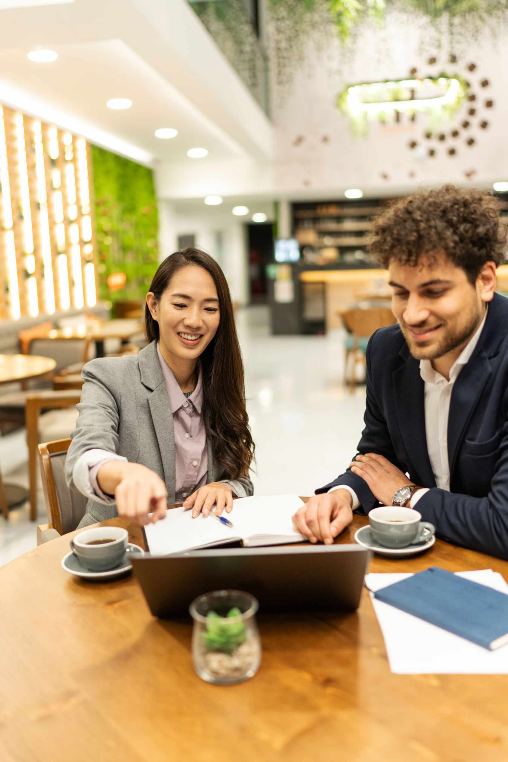 Geschäftsleute, die mit einem Laptop in einem Café an einem Projekt zusammenarbeiten