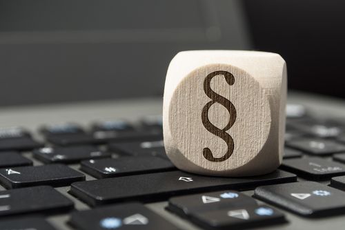 Würfel auf Tastatur mit Paragraph