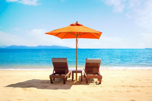 Liegen mit Sonnenschirm am Strand