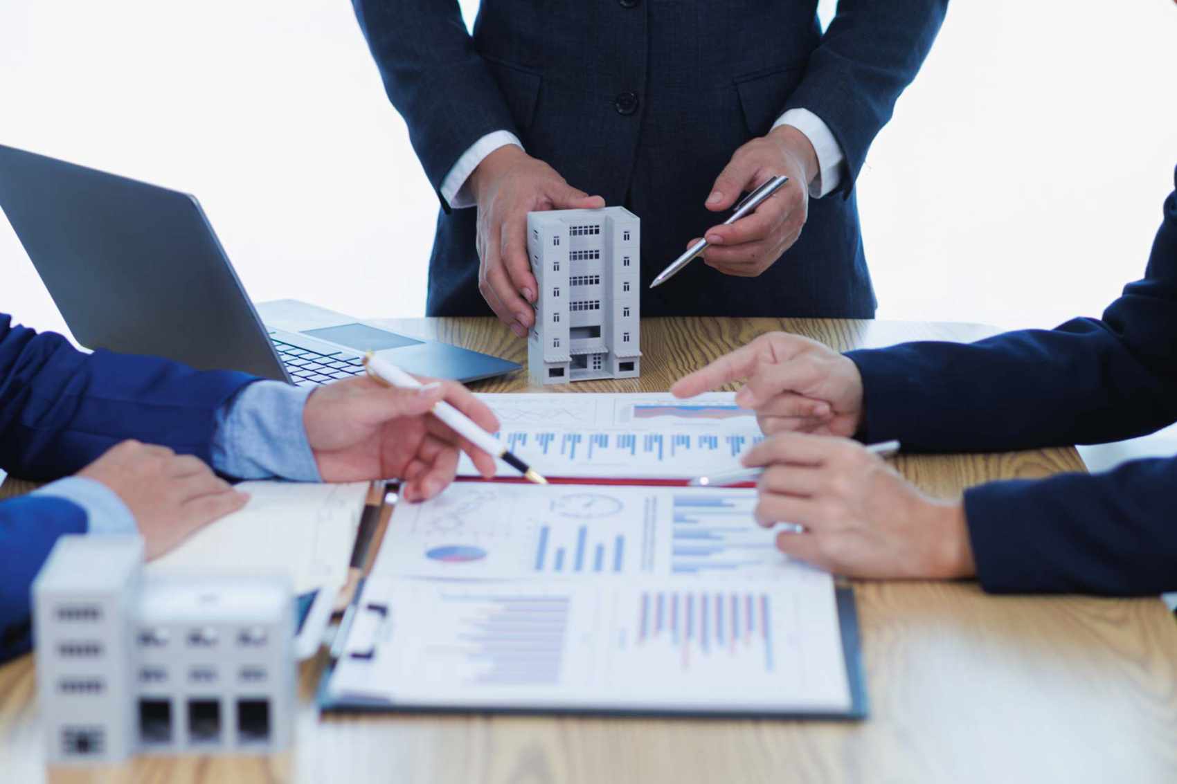 Eine Gruppe von Geschäftsleuten und Investoren erörtert Investitionen in Immobilien und plant gemeinsam Investitionen in Bauprojekte von Eigentumswohnungen und Mietwohnungen.